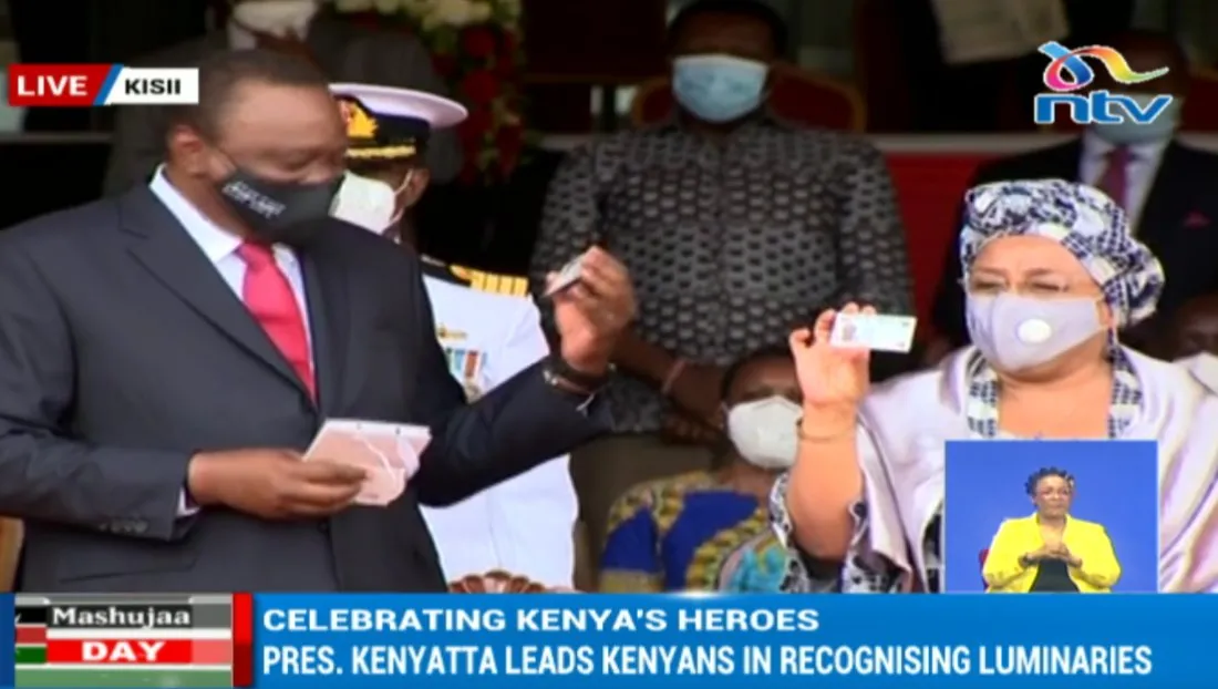President Uhuru Kenyatta and First Lady Margaret Kenyatta holding the Sample Huduma Namba Cards during 2020 Mashujaa Day Celebrations at Gusii Stadium in Kisii County.